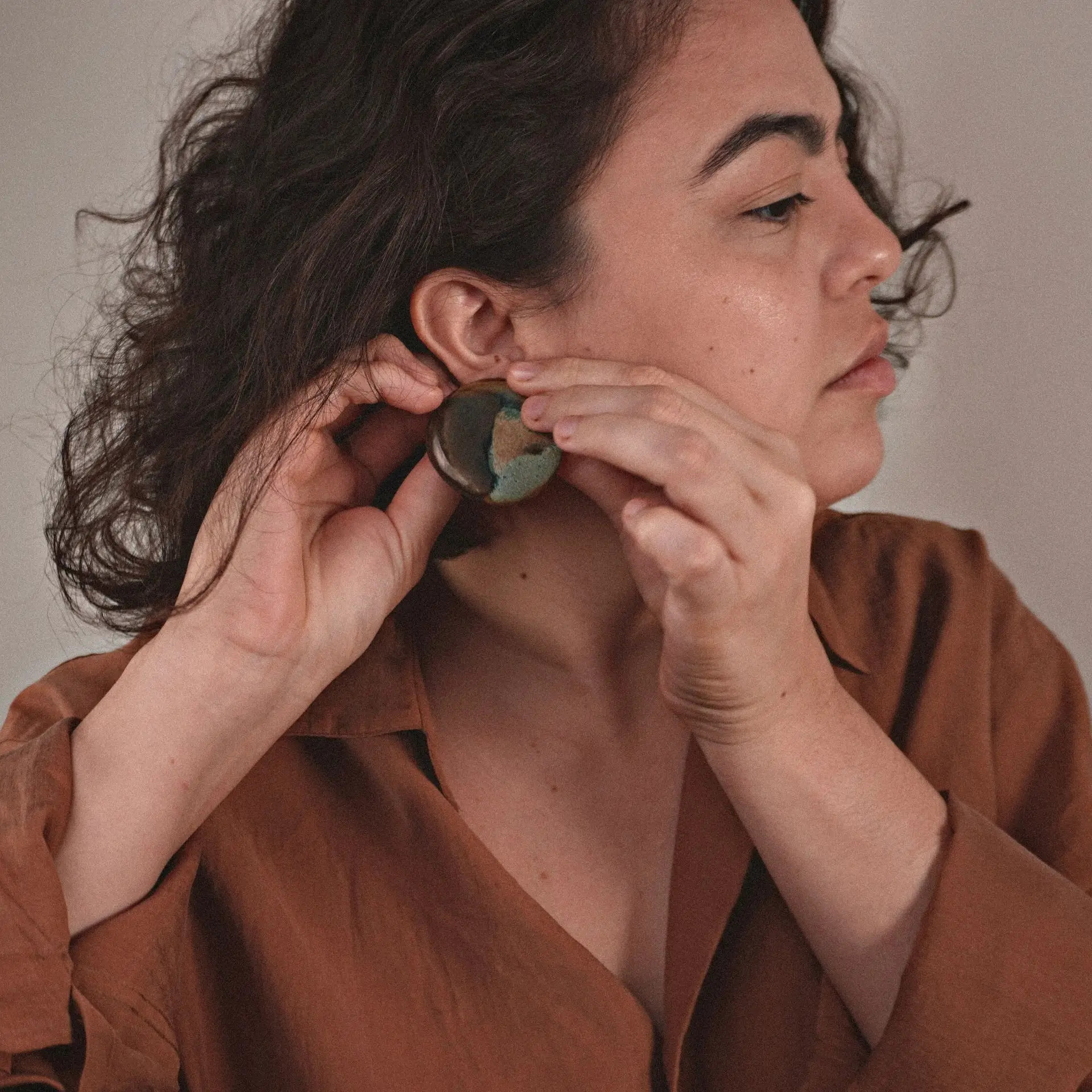Lorena Vieira usando um brinco de cerâmica do Ateliê Crua